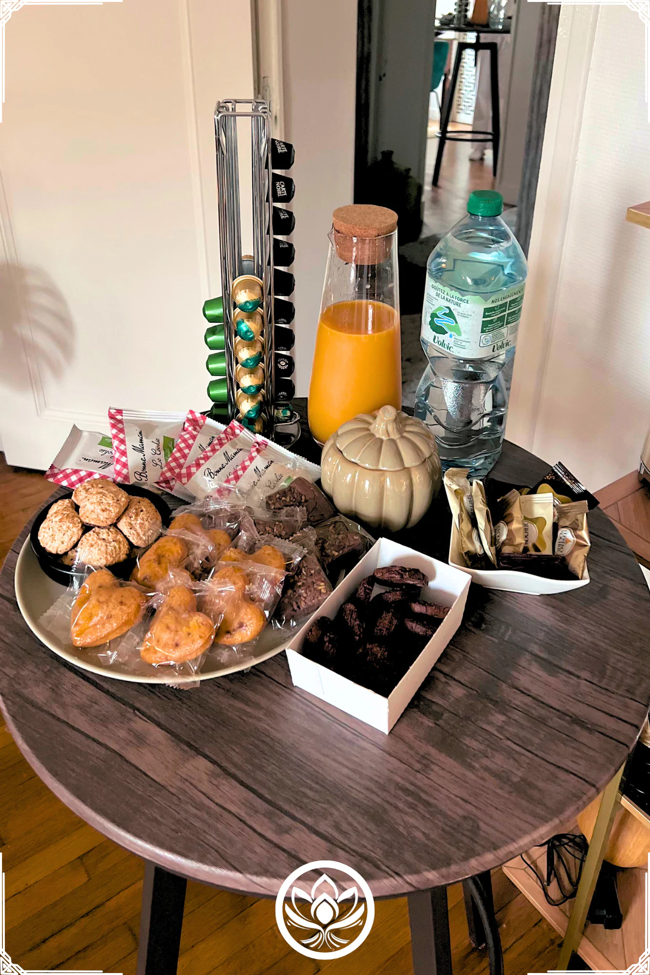 Table d'accueil avec jus, eau, douceurs et capsules, pour une pause reconfortante avant ou apres votre massage au cabinet.