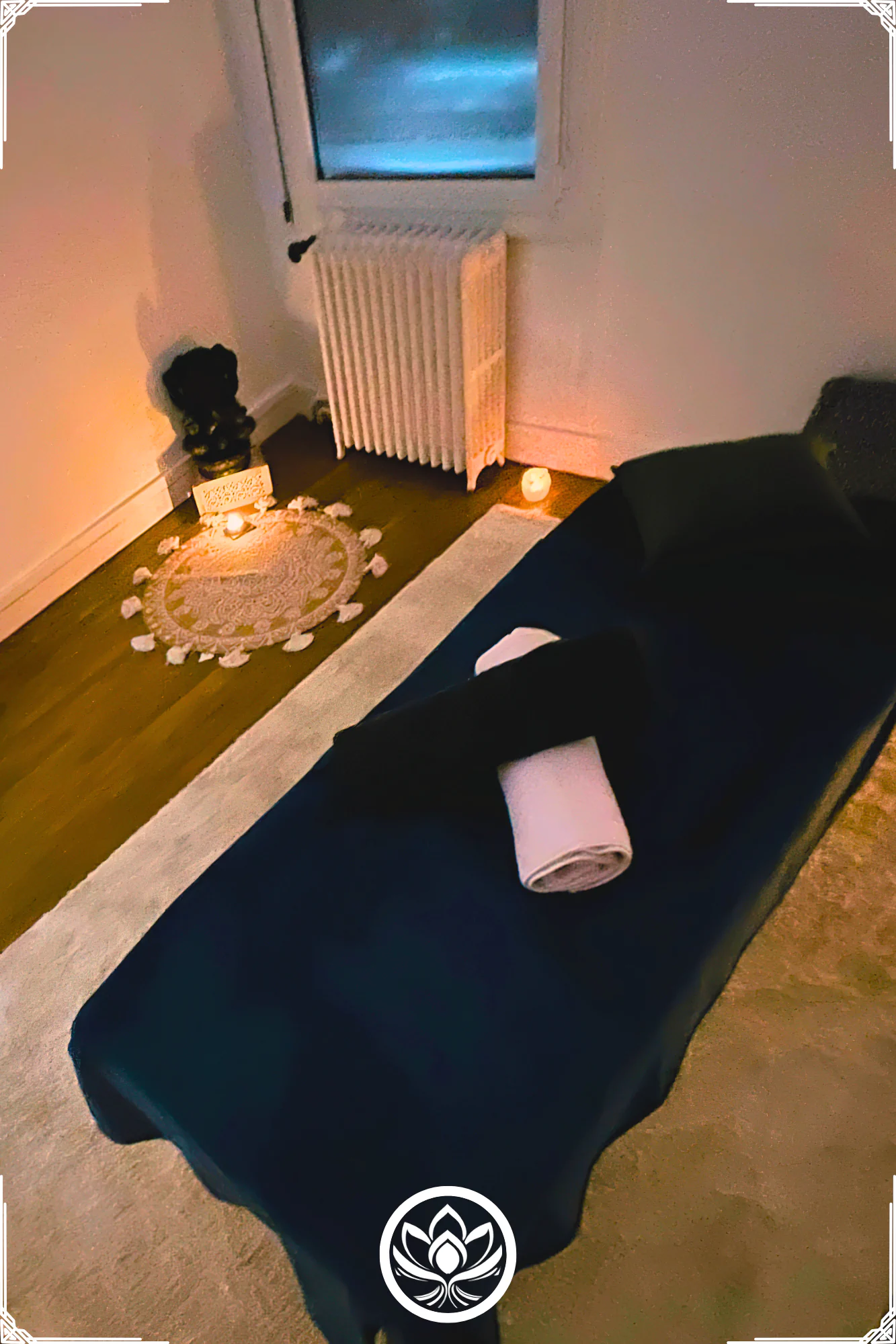 Table de massage avec drap sombre, serviette pliee, bougies et ambiance intime, ideale pour une detente profonde.