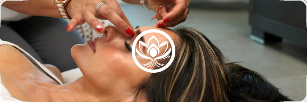 Soin visage en cabinet, praticienne au dessus du regard, gestes fins, drainage et points de pression, massage Kobido.